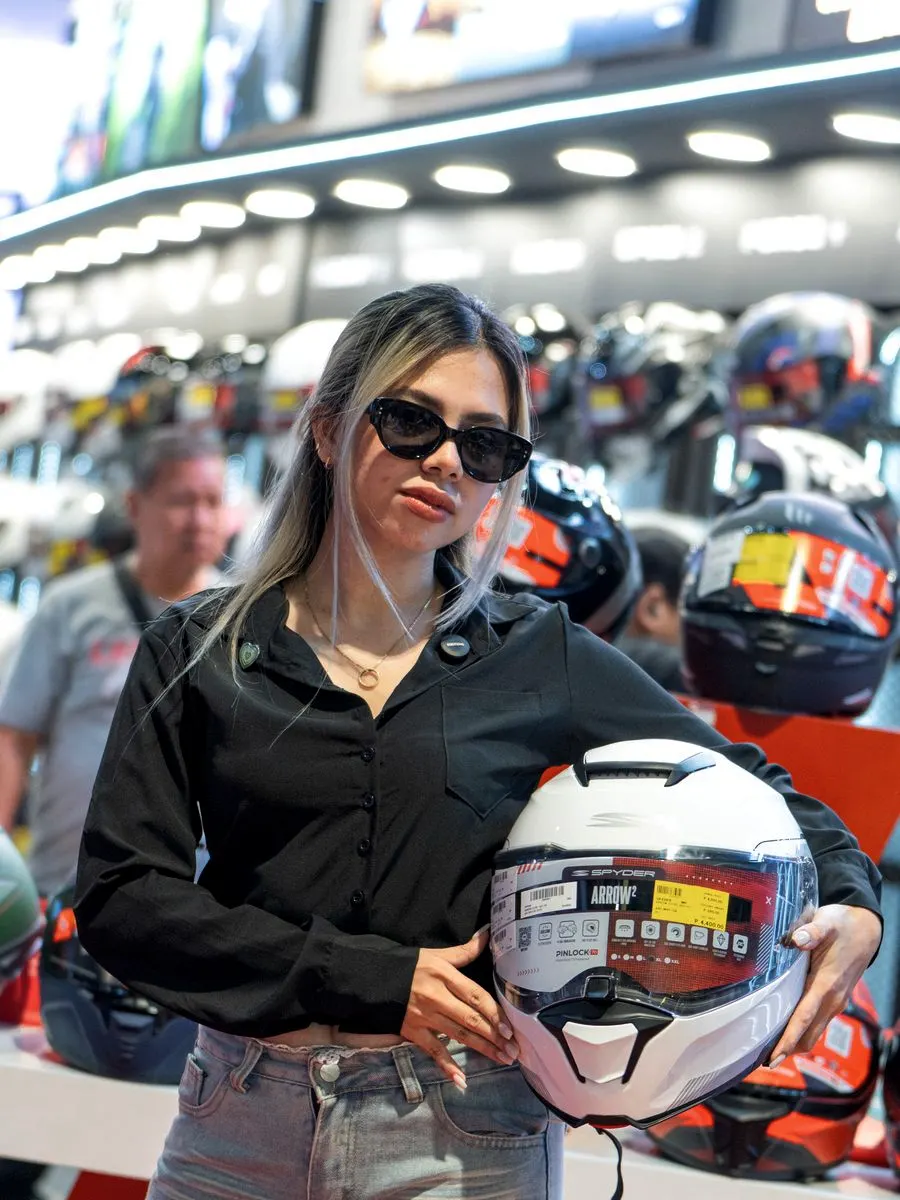 A team member holding a helmet at the booth during a motorcycle show