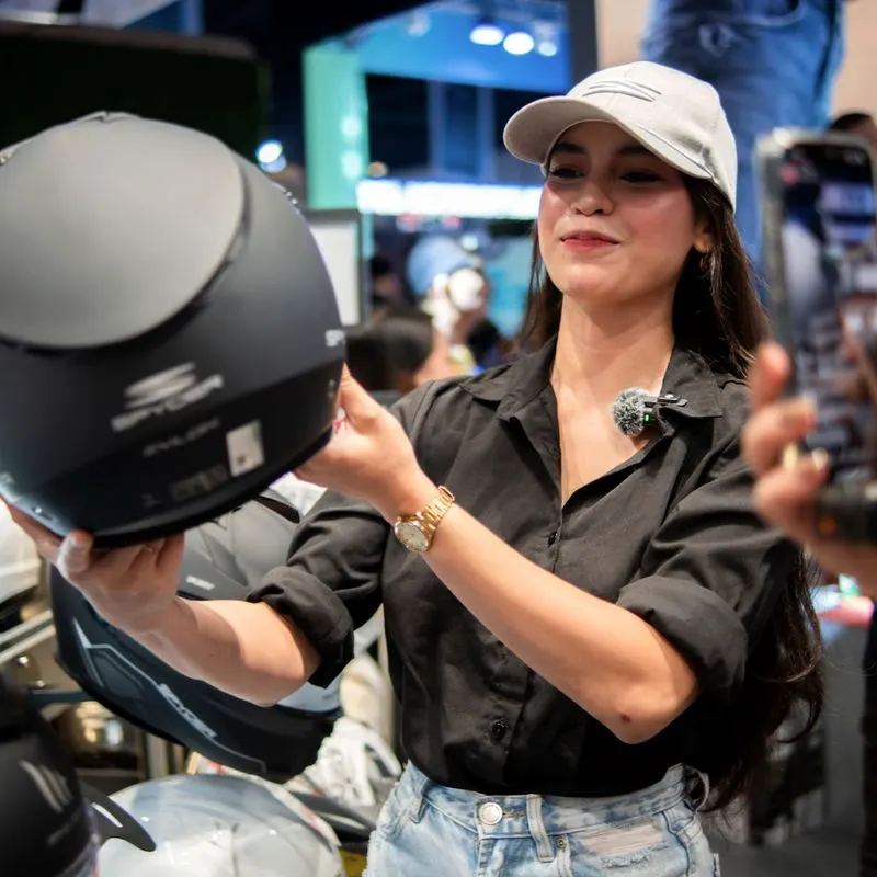 A team member showing a helmet to a customer at an event