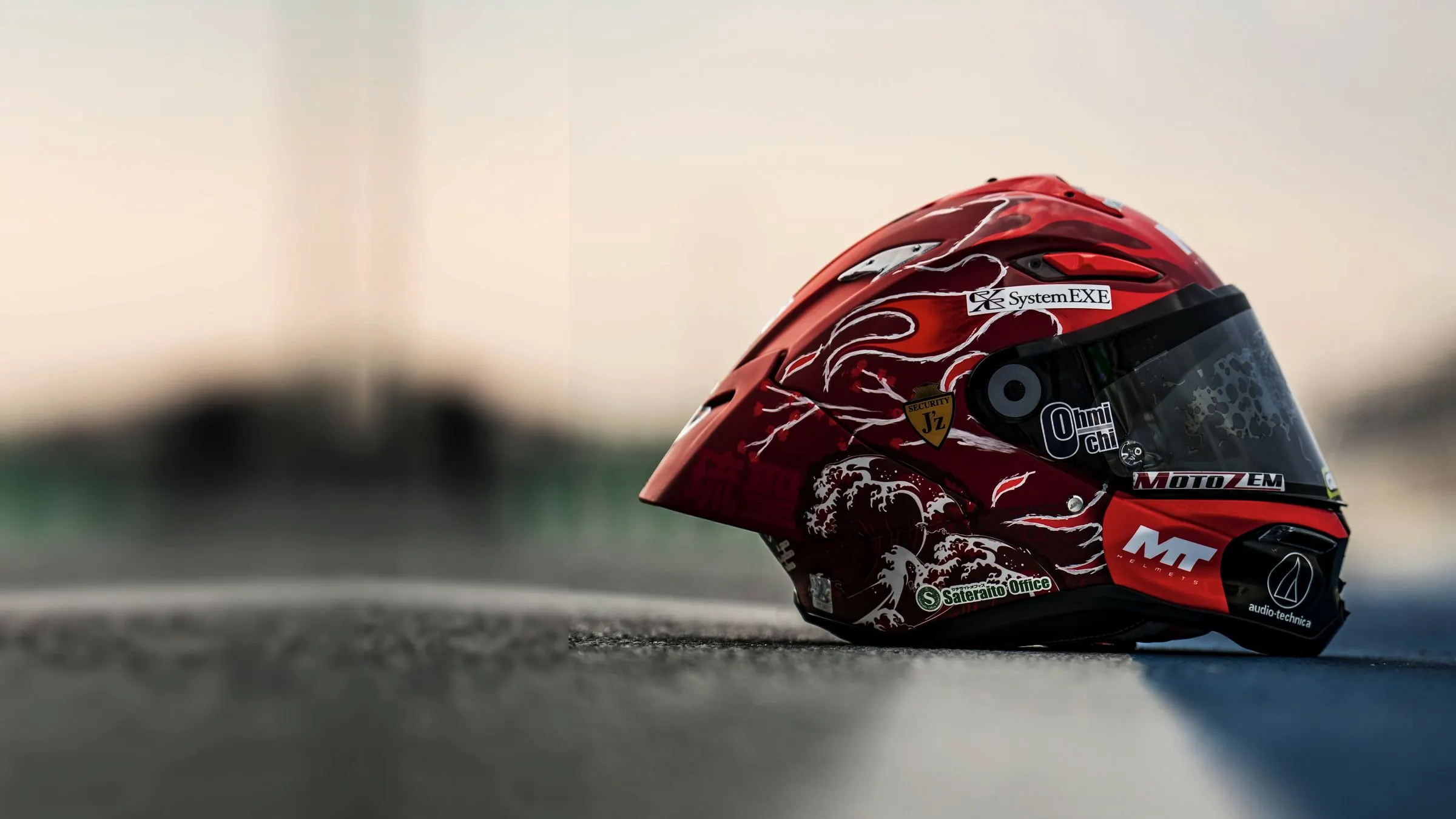 An MT Helmets race helmet resting on the track